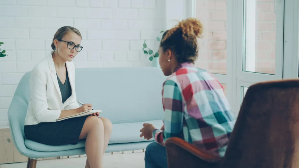 Client and therapist having a face-to-face conversation during a mental health counseling session in a calm indoor setting